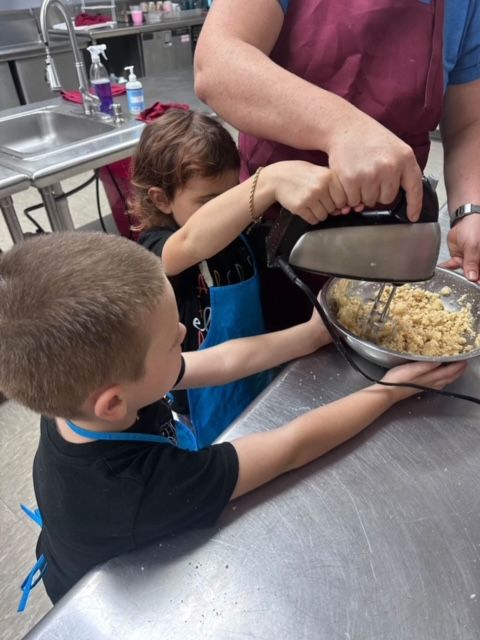 Kids mixing dough in cooking class